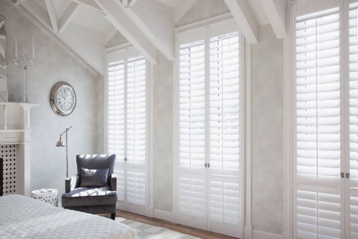 Norman® Plantation Shutters in a well-lit bedroom near Eugene, OR, during the day